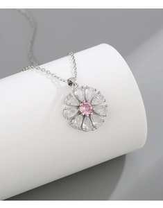 Gros plan d'un collier fleur avec zircon rose et pétales en pierres blanches goutte