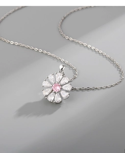 Gros plan du collier fleur avec zircon rose central et pétales en forme de poire