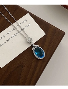 Détail du pendentif saphir avec halo de diamants et fine chaîne en argent