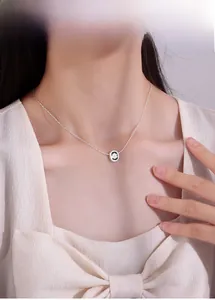 Close-up of minimalist daisy flower pendant on silver chain worn by a model