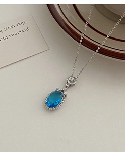 Détail du collier pierre bleu saphir avec chaîne florale argentée et petits cristaux