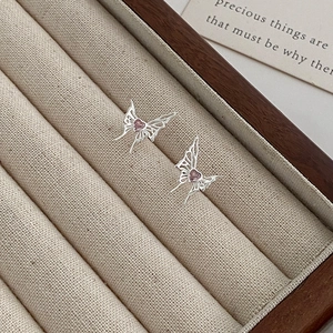 Elegant liquid butterfly stud earrings with pink heart gemstones in a jewelry box