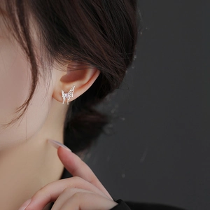 Elegant silver butterfly stud earrings with purple heart gemstone on female model