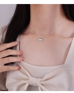 Close-up of a vintage daisy pendant necklace on a model's neck for a trendy minimalist look