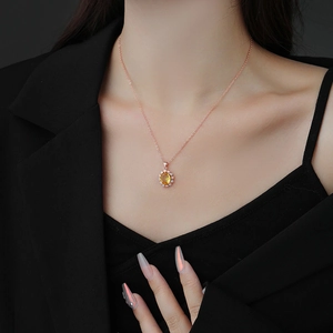 Collier élégant en or rose avec pendentif ovale en pierre jaune sur un mannequin