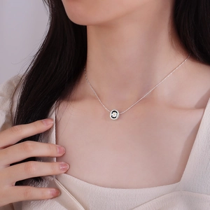 Minimalist daisy pendant necklace with black enamel and silver chain on model neck
