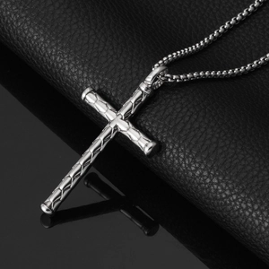 Macro detail of silver stainless steel cross pendant with snakeskin texture and box chain