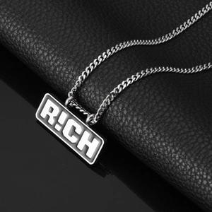Gros plan du pendentif argenté RICH avec une chaîne à maillons cubains de style hip-hop