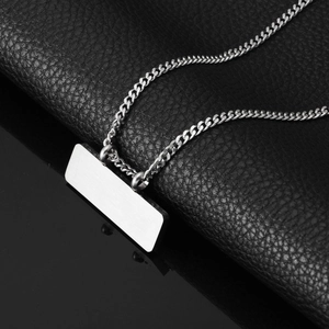 Détail d'une chaîne cubaine en acier titane argenté avec pendentif rectangulaire brossé