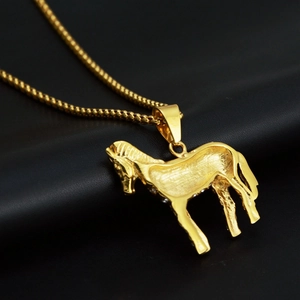 Detail einer goldenen Hengst-Halskette auf einer schwarzen Lederoberfläche