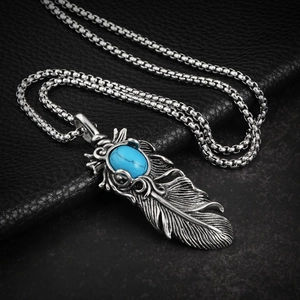 Gros plan du pendentif plume en acier inoxydable avec pierre turquoise bleue incrustée
