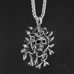 Macro-opname van vintage zilveren schedelhanger met slangmotieven en een box ketting