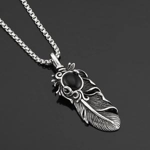 Détail d'un collier pendentif plume en argent vintage avec incrustation d'onyx noir