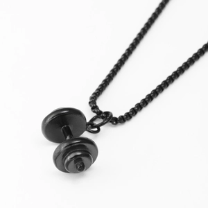 Macro shot of a matte black dumbbell pendant on a round bead chain with minimalist design