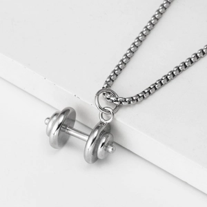 Macro shot of polished silver dumbbell pendant necklace with fine box chain detail