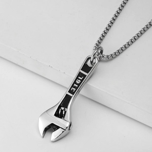Vue macro d'un pendentif en forme de clé en acier inoxydable 316L avec sa chaîne