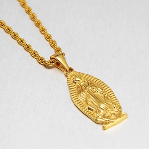 Macro shot of Virgin Mary pendant on a gold rope chain necklace with diagonal focus