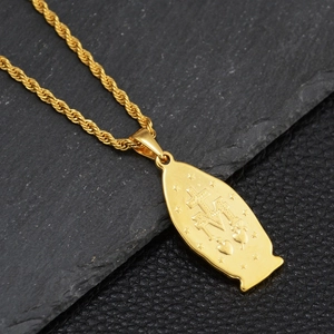 Detailed close-up of religious symbols and cross engraving on golden Saint Mary pendant