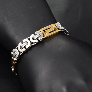 Hiphop Armband in Silber und Gold mit Mäander-Muster auf schwarzem Armmodell gezeigt