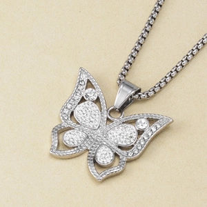 Macro shot of silver butterfly pendant with white rhinestones on a stainless steel chain