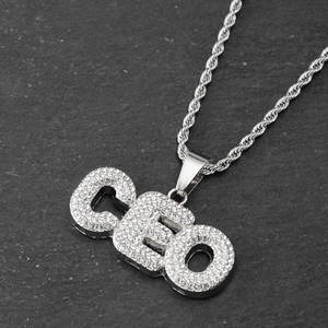 Macro shot of silver hip-hop CEO pendant encrusted with diamonds on a rope chain