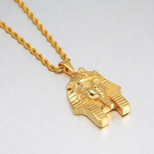 Macro shot of gold Egyptian Pharaoh pendant with rope chain showing fine relief details