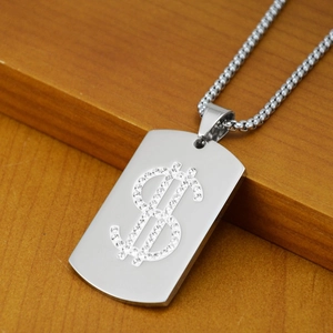 Détail du pendentif dollar argenté avec chaîne à billes sur surface en bois