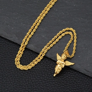 Collar hip hop con colgante de ángel dorado y cadena de cuerda sobre piedra con textura