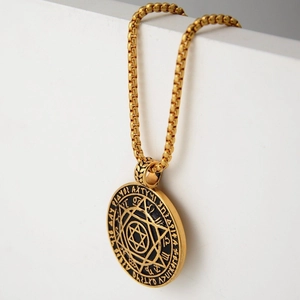 Makroaufnahme der goldenen Vintage-Medaillon-Halskette mit Hexagramm und Gravur