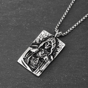 Macro detail of gothic grim reaper skull pendant with relief carving on box chain necklace