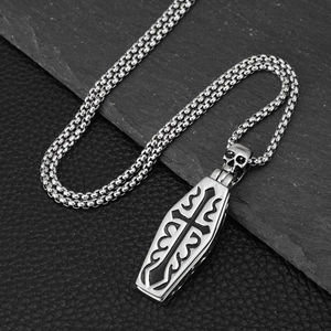 Gothische Sarg-Halskette aus Edelstahl mit Totenkopf-Detail und Box-Kette auf Stein