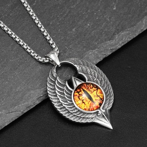 Macro shot of punk flying eagle pendant with yellow evil eye on grey slate base