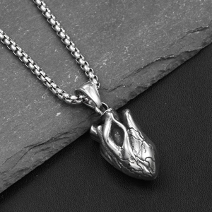 Vue macro du pendentif cœur anatomique en argent vintage sur une chaîne à mailles