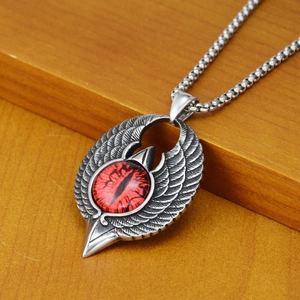 Detailed close-up of gothic eagle wing pendant with red demon eye and silver bead chain