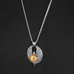 Detail of gothic eagle wing pendant with orange dragon eye on a stainless steel chain