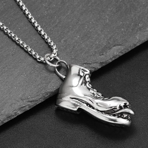 Gros plan détaillé du pendentif botte monstre en argent rétro avec crocs et style gothique