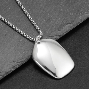 Detailed close-up of a polished rectangle pendant with box chain on dark rock background