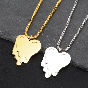 Primo piano di ciondoli a cuore fuso in oro e argento su catene a maglia quadrata