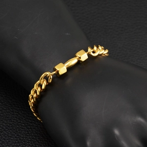 Detail eines vergoldeten Edelstahl-Hantelarmbands mit einer dicken Panzerkette
