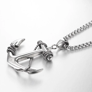 Detailed macro view of silver anchor pendant with rope texture and stainless steel box chain