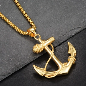 Macro view of golden anchor pendant with intricate rope detail and polished metal finish