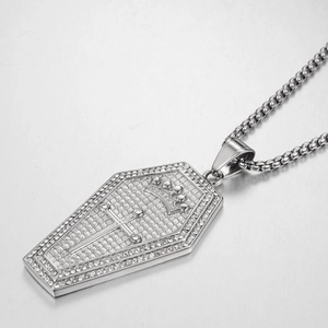 Detail of silver coffin pendant with inlaid rhinestones, cross, and crown on box chain