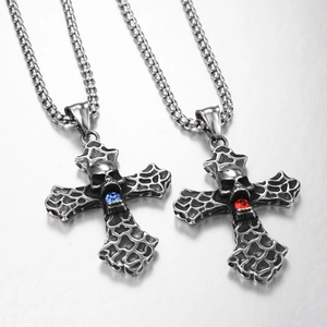 Détail d'un pendentif croix gothique en acier inoxydable avec crâne et pierre bleue ou rouge