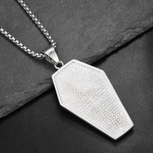 Close-up of hip-hop coffin pendant necklace with pavé-set stones on stainless steel chain