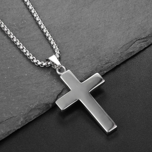 Vue macro détaillée du pendentif croix en acier inoxydable poli sur une chaîne à billes
