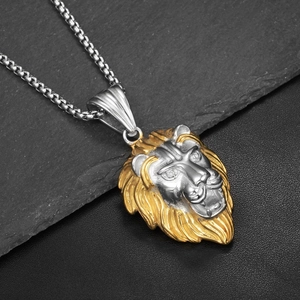 Gros plan du pendentif tête de lion bicolore avec crinière dorée et chaîne maille