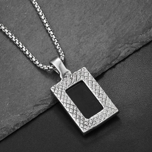 Vue macro d'une chaîne vénitienne en argent et pendentif rectangulaire noir