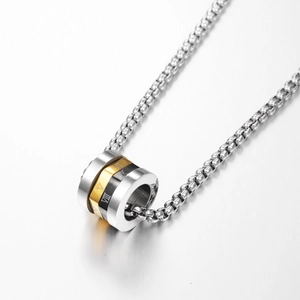 Macro shot of three-tone cylinder pendant with Roman numeral engravings on steel chain