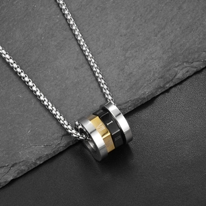 Macro shot of three-tone cylinder rings with Roman numerals on sleek steel chain