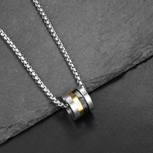 Detail of tricolor titanium steel pendant with engraved Roman numerals on grey stone